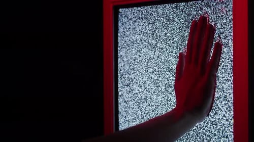Hand Presses Against Vintage Television Static