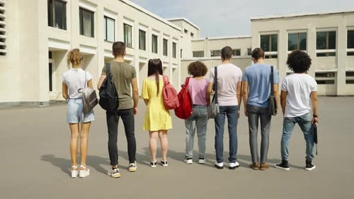 Students Standing with Their Backs to Camera Near College