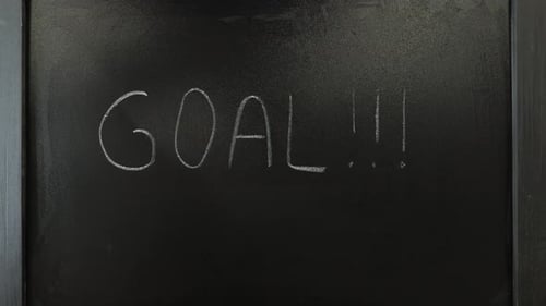 Hand Writes Goal on Chalkboard