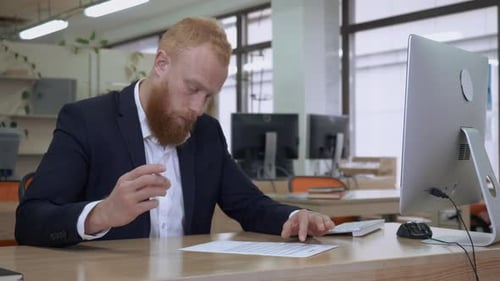 Man Signs Document in Modern Office Setting