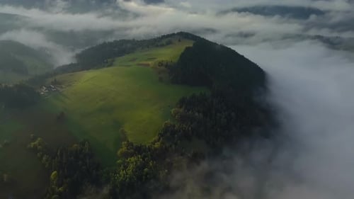 Aerial View of Foggy Mountains and Green Landscape