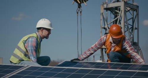 Técnicos que instalan paneles solares bajo el sol