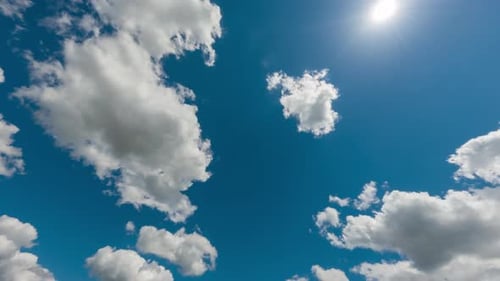 Time lapse fast moving white clouds and blue sky.