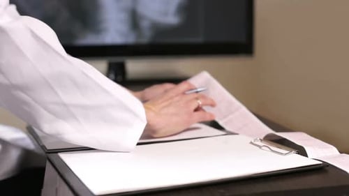 Doctor cardiologist makes records of the result of the analysis of the cardiogram in the hospital.
