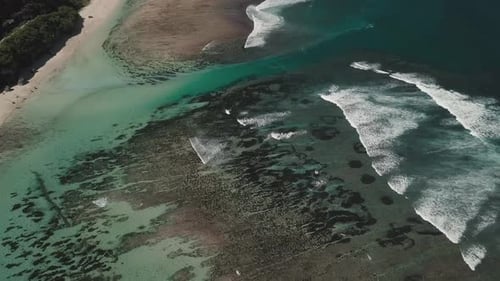 Luftaufnahme des tropischen Strandes mit azurblauem Wasser und schäumenden Meereswellen