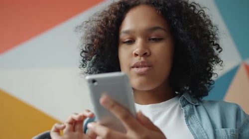Smiling Young Woman Using Smartphone Indoors