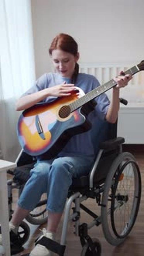 Woman in Wheelchair Plays Guitar and Sings