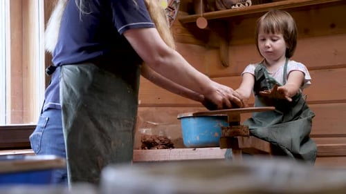 Girl Learning Pottery Wheel Craft with Instructor