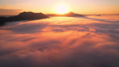 Vol panoramique 4K au-dessus d'un magnifique paysage de montagne avec un ciel lumineux et des nuages au lever du soleil d'été
