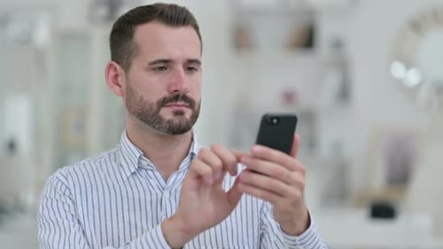 Portrait of Positive Young Man Using Smartphone