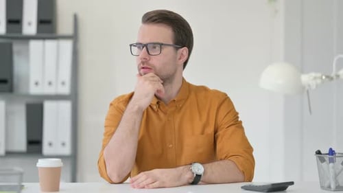 Young Man Thinking in Office