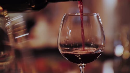 der Kellner gießt Rotwein in die Gläser