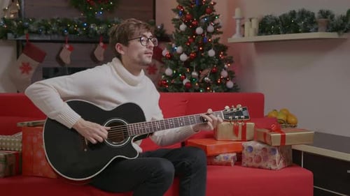 Young Man Plays Guitar for Christmas
