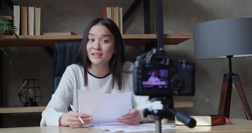 Blurred Silhouette of Asian Woman Videoblogger Filming New Vlog Video with Professional Camera