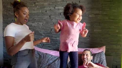 Happy Family Dancing and Jumping on Bed at Home