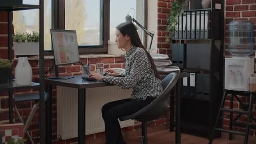 Woman Working at Desk in Modern Office, Frustrated