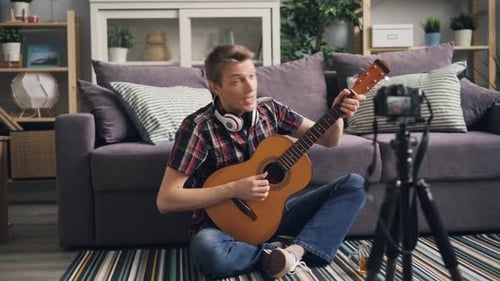 Young Man Plays Guitar for Video Recording at Home