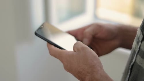 Männliche Hände tippen Nachricht auf dem Smartphone.