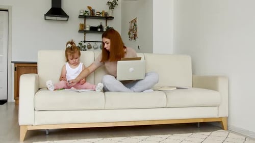 Mother Working From Home Having a Work Video Call While Her Child Distracts and Drawing Attention