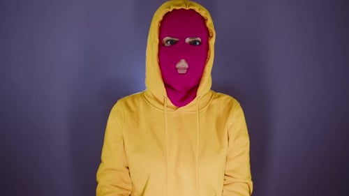 Woman Wears Pink Balaclava and Yellow Hoodie