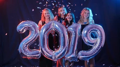 Smiling Women Celebrating New Years Holding Balloons