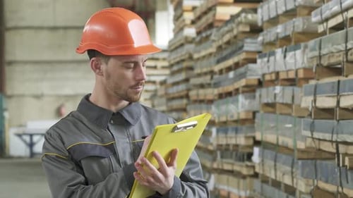 Warehouse Worker Writing on His Clipboard Standing at the Storage