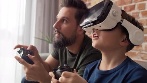 Father and Son Playing Video Games With VR Headset