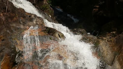 Waterfall Cascading Over Rocks in Lush Nature