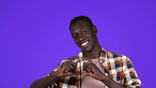 Man Smiling and Making Heart Shape With Hands