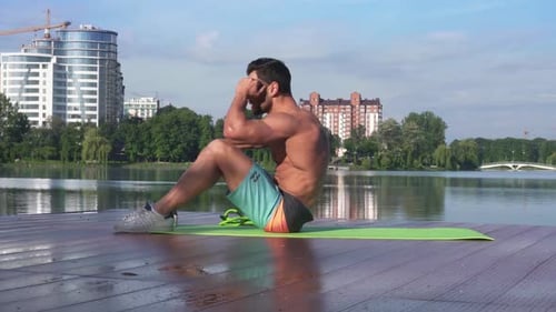 Handsome Fitness Model Doing Abdominal Crunches on Yoga Mat