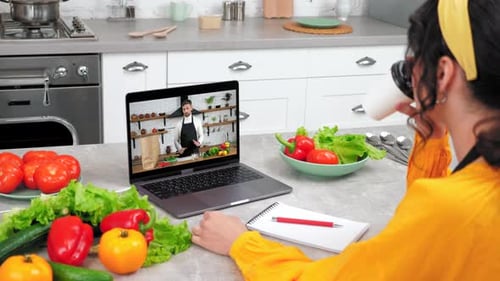 Woman Takes Online Cooking Class in Kitchen