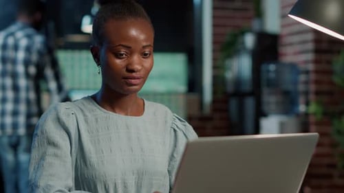 Woman Working on Laptop in Modern Workplace