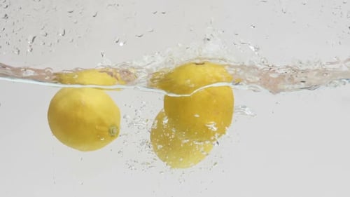Lemons Splashing Into Water