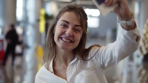Woman Smiling Holding Passport and Ticket at Airport