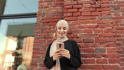Smiling Woman with Headscarf Using Cell Phone