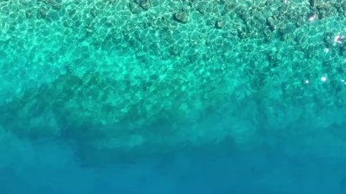 Wellen und azurblaues Wasser als Hintergrund. Blick von der Drohne auf die Meeresoberfläche.