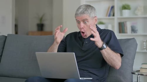Man Using Laptop Expressing Shock and Surprise