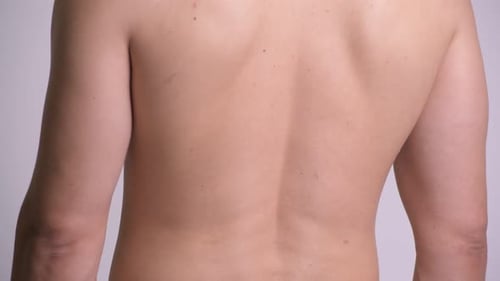 Körper eines gutaussehenden muskulösen Mannes ohne Hemd vor weißem Hintergrund