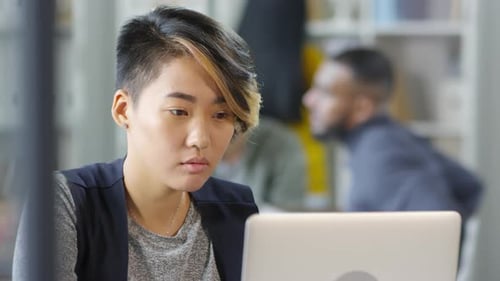 Young Woman Working on Laptop in Modern Office