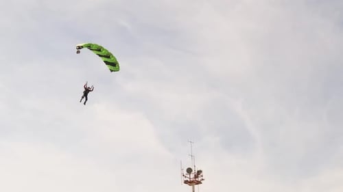 Der Fallschirmspringer fliegt und landet im Feld Extremsport auf dem Boden