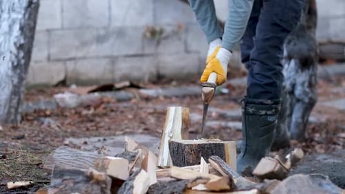 Person Chopping Wood with Splitting Wedge Outdoors