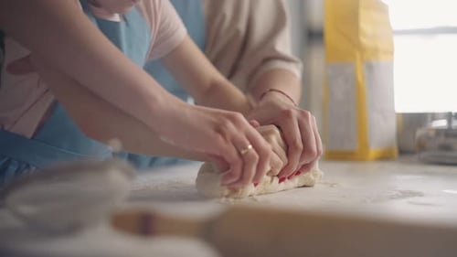 Little Girl and Her Mother are Kneading Dough in Home Kitchen Cooking and Baking Domestic Bread