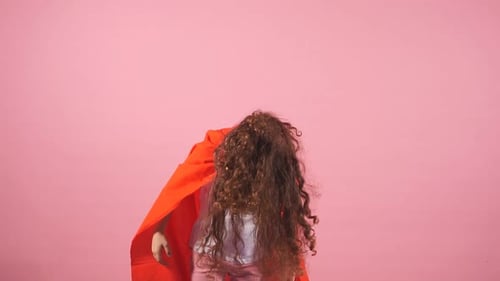 Girl in Superhero Costume Playing on Pink Background