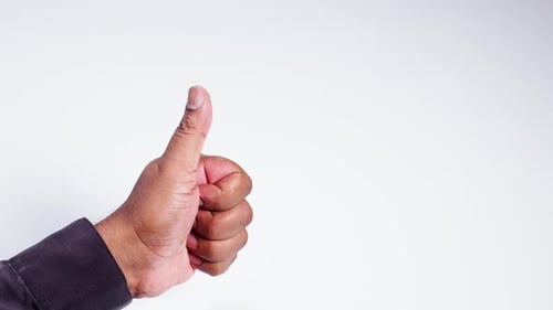 Hand Shows Thumbs Up Gesture on White Background