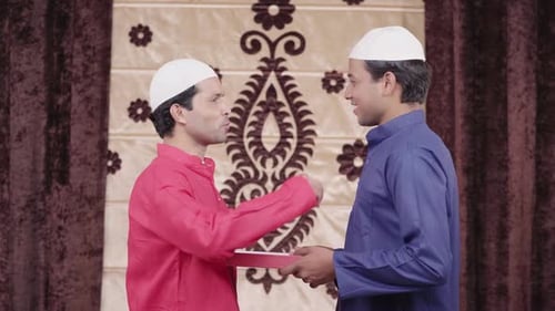 Man giving sweets to his friend on Eid