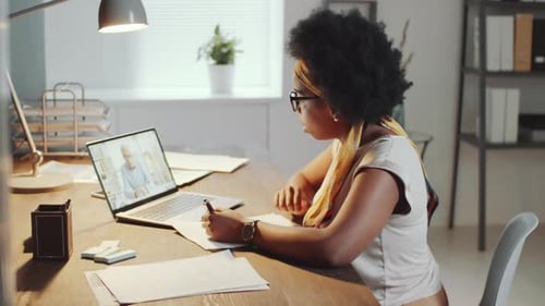 Afro-American Female Office Worker Video Calling on Laptop