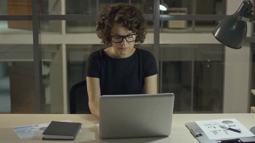 Femme d'affaires sérieuse travaillant la nuit