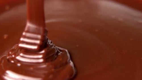 Rich Chocolate Pours Over a Smooth Surface