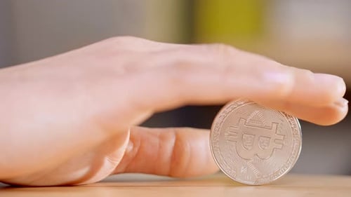 Hand Holding Silver Bitcoin Cryptocurrency Coin Close Up