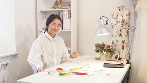 Young Attractive Clothing Designer Sits Down at His Desktop To Create a New Clothing Design